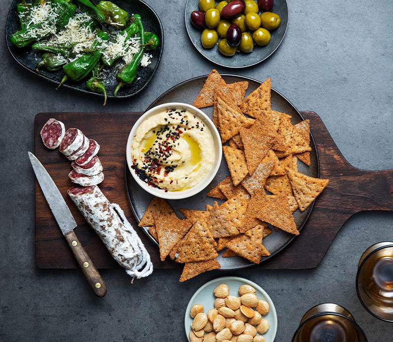 Enkla tapas med snacks, hummus, marconamandlar och oliver